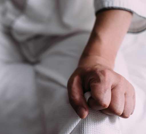 Hand anxiously gripping a piece of clothing.